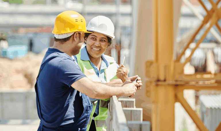 Two construction workers wearing hard hats and safety gear talking at a job site – legal assistance for workplace injury claims in Connecticut.