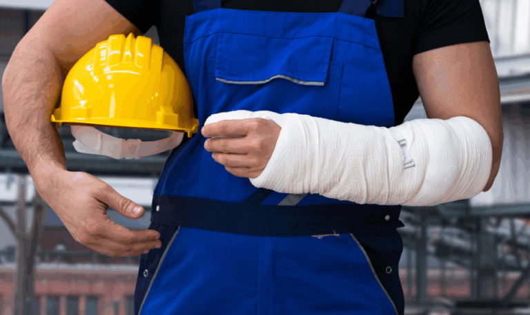 Construction worker in blue overalls holding a yellow hard hat with a heavily bandaged arm, representing a work-related injury in Connecticut