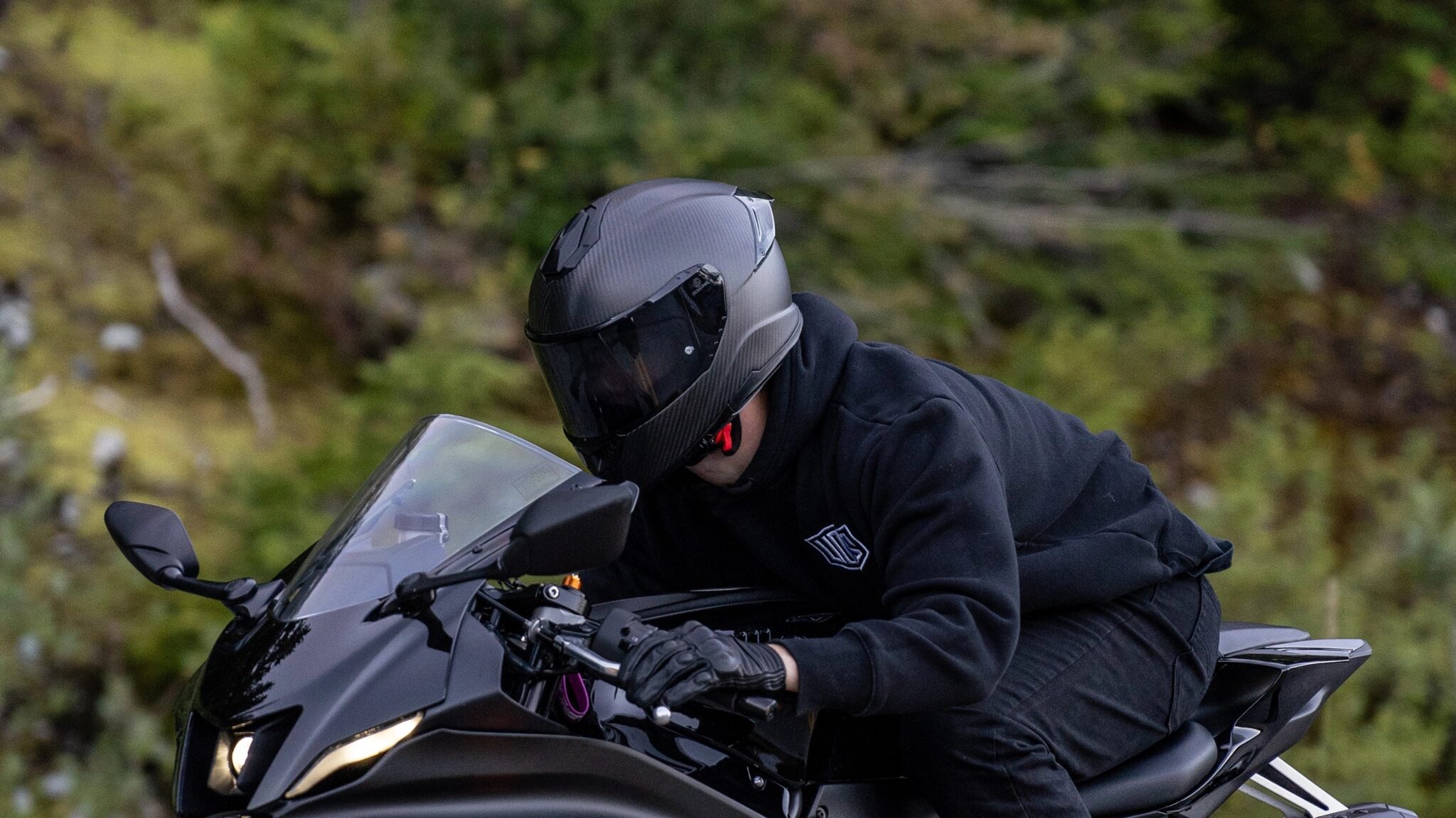 Motorcyclist wearing helmet, illustrating 2025 helmet laws in Connecticut. Motorcyclist wearing a helmet on a black sportbike in Connecticut – 2025 motorcycle helmet law guide